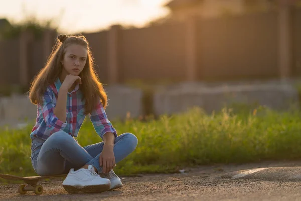 Humeurig Jonge Vrouw Zit Haar Skateboard Aandachtig Staren Naar Camera — Stockfoto
