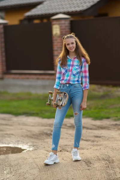 Trendy Jonge Vrouw Met Haar Skateboard Staande Buitenshuis Kijken Naar — Stockfoto