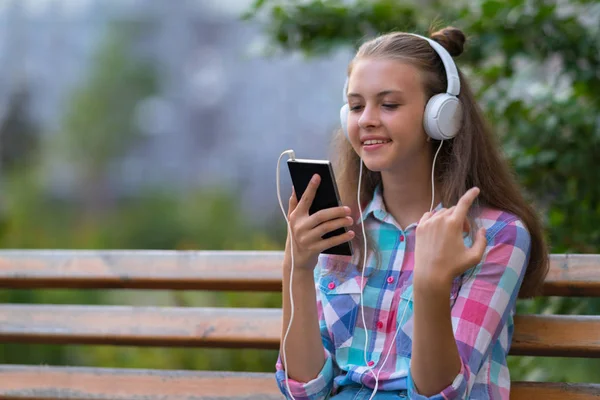 Mujer Joven Sentada Banco Del Parque Escuchando Música Teléfono Móvil —  Fotos de Stock