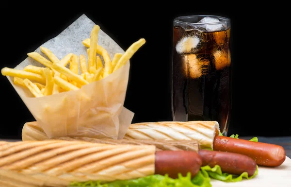 Hoge Frisdrank Glas Met Ijs Naast Frites Plasticfolie Hotdogs Verpakt — Stockfoto