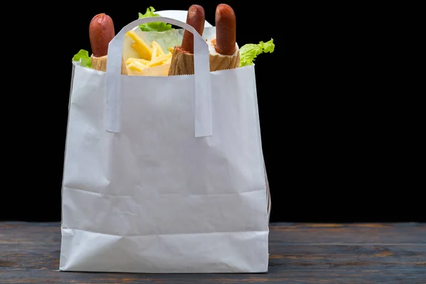 Witte Zak Gevuld Met Hotdogs Sla Bladeren Zitten Houten Tafel — Stockfoto