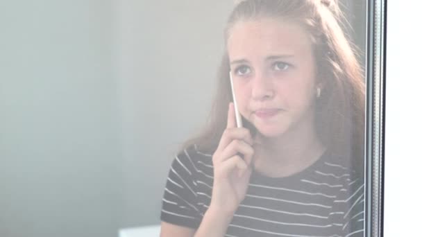 Troubled young girl talking on a mobile phone — Stock Video