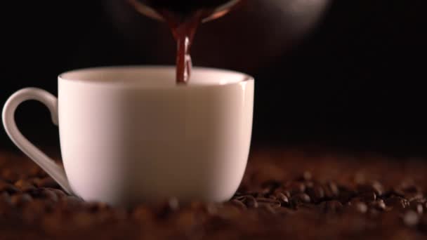 Person pouring brown liquid into small cup — Stock Video