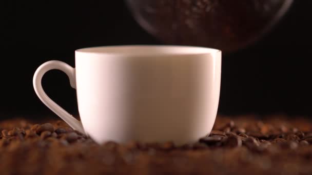 Кофе наливается в кружку сидя на кофейных зерен — стоковое видео