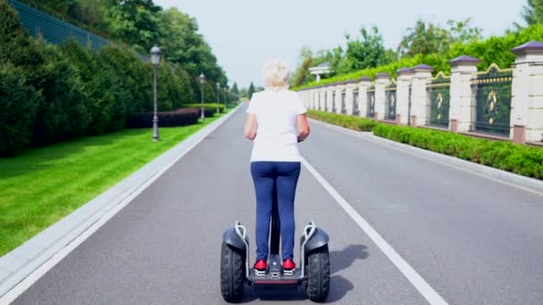 Femme chevauchant un transporteur personnel électrique — Video