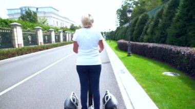 Kadın kameradan uzak bir elektrikli Kişisel taşıyıcı üzerinde sürme
