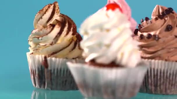Vier verschiedene Cupcakes mit gewirbeltem Zuckerguss — Stockvideo