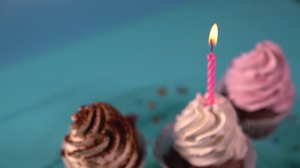 Вечеринка свечи на розовом остекленном кексе — стоковое видео