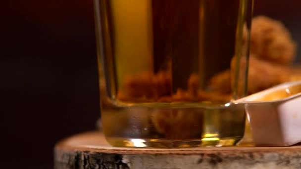 Glass of lager, fried chicken wings and chips — Stock Video