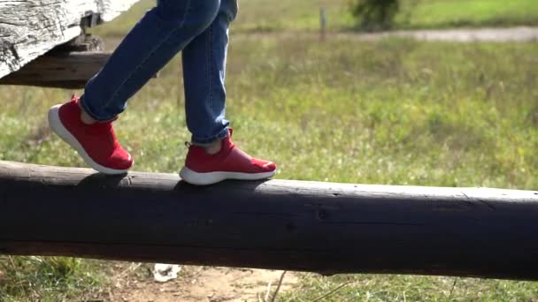 Mujer en zapatos rojos caminando a lo largo de un palo de madera — Vídeos de Stock