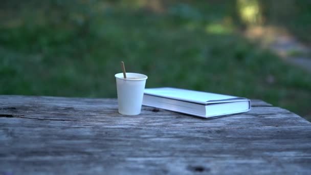 Café para llevar y libro sobre mesa de madera vieja — Vídeos de Stock