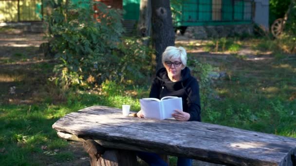 Zoom sur une femme d'âge moyen lisant un livre — Video