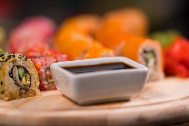 Düşük açılı görünümü kadar yakın kase soya sosu bir suşi kurulu taze çiğ balık ve deniz yosunu ile rulo