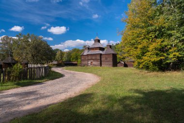 Rustik eski ahşap outbuildings bir kırsal yol yapraklı yeşil ağaçlar ve düzgün çim üzerinde