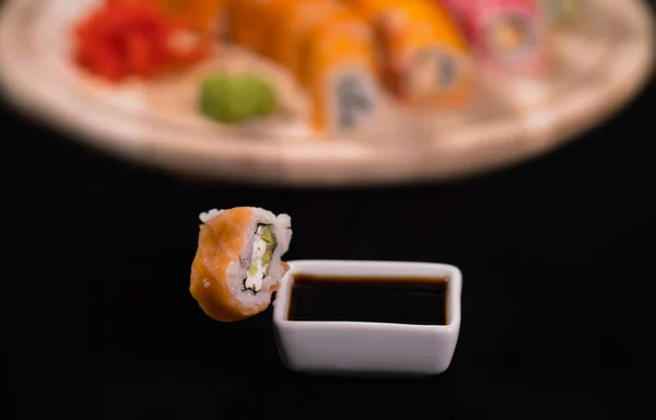 Piece of fresh California maki sushi with soya sauce