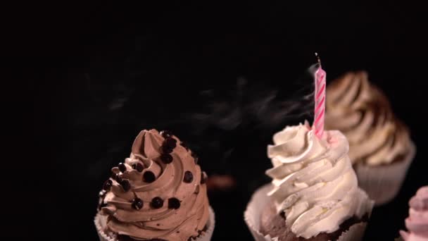 Apagando una vela de cumpleaños en un cupcake helado — Vídeos de Stock