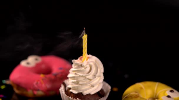 Brennende Kerze auf einem Cupcake, der ausgeblasen wird — Stockvideo