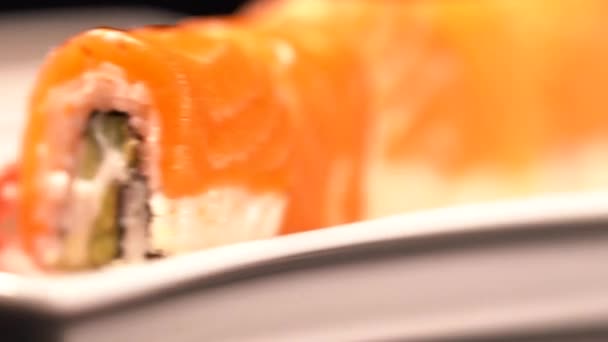 Rolos de sushi de salmão e wasabi em uma chapa giratória — Vídeo de Stock