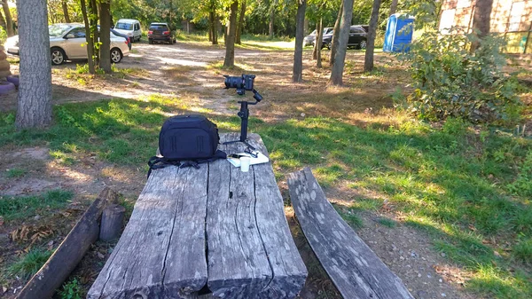 Kameraausrüstung Mit Tasche Und Gimbal Aufgestellt Auf Einer Parkbank — Stockfoto