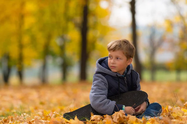 Een Eenzame Jonge Jongen Zitten Onder Herfst Herfstbladeren Een Park — Stockfoto