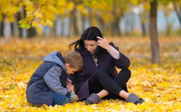 Figlio Madre Curiosi Seduti Parco Tra Autunno Foglie Autunnali — Foto Stock