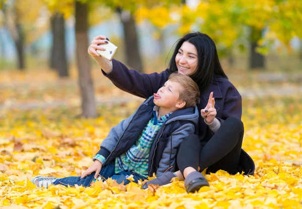 Улыбающаяся Мать Своим Непослушным Сыном Позирует Селфи Мобильном Телефоне Осеннем — стоковое фото
