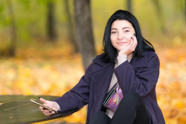 Frau Sitzt Einem Tisch Einem Herbstlichen Wald Und Hält Ihr — Stockfoto