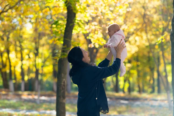 Šťastná Matka Drží Své Dítě Hravě Vzduchu Jasných Podzimní Park — Stock fotografie