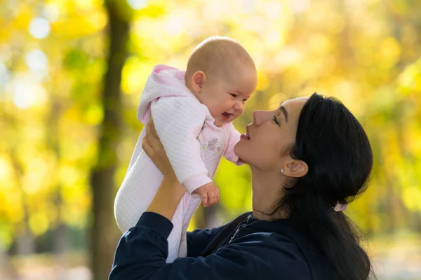 愛する母を美しい 明るい秋の光と公園のシーンで彼女の幸せな 笑い赤ちゃんと遊ぶ — ストック写真
