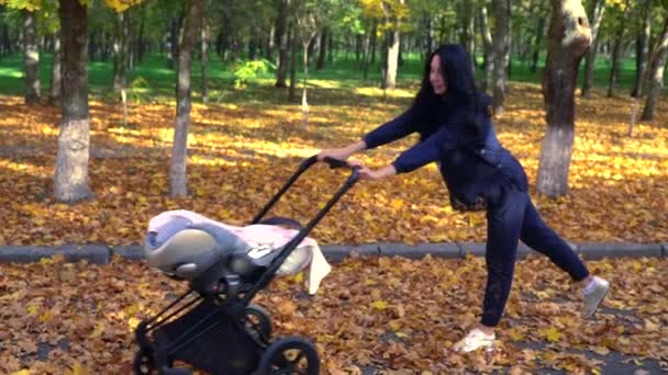 Mujer rodando bebé cochecito de ida y vuelta — Vídeo de stock