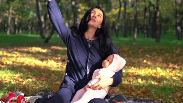 Hermosa madre con su bebé en el parque — Vídeo de stock