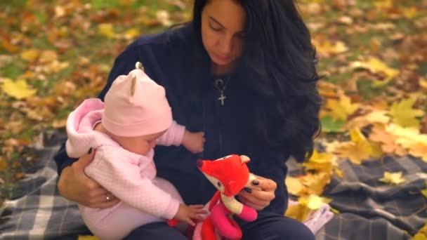 Piękna młoda kobieta z małym dzieckiem w parku — Wideo stockowe