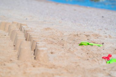 Yaz tatili kavramsal bir tropikal plajda saksı kum satırlarının yanında plastik yeşil ve pembe çocuk oyuncakları