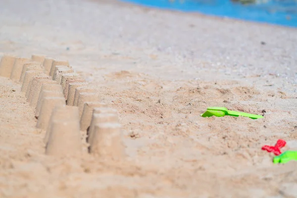 熱帯のビーチの夏の休日の概念の鉢植えの砂の行と一緒にプラスチックの緑とピンクの子供のおもちゃ — ストック写真