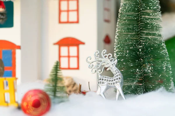 在圣诞场景中 有雪树和古色古香的五颜六色的模型房子 闪亮的银丝驯鹿装饰 — 图库照片