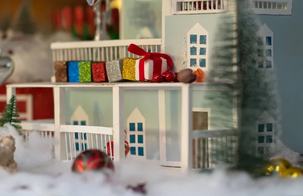 Toy Christmas decoration with house and colorful wrapped gifts, Baubles and winter snow to celebrate the holiday season