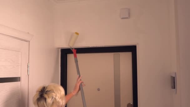 Woman painting her house using a long roller — Stock Video