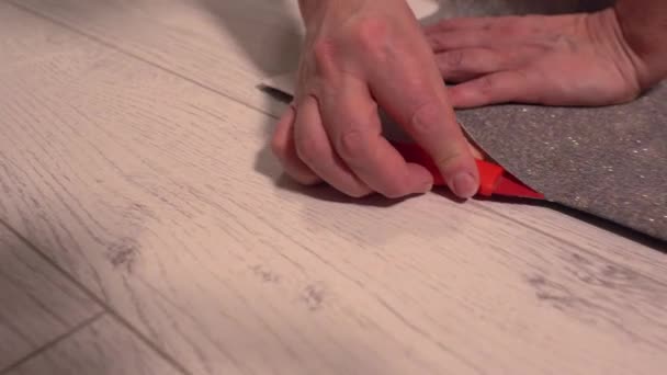 Personne coupant une longueur de papier peint — Video
