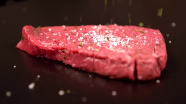 Готовим сырой говяжий стейк — стоковое видео