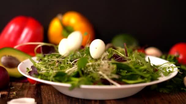 Huevos cocidos de codorniz sin cáscara que caen en una ensalada — Vídeo de stock
