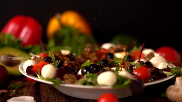 Chef reibt schwarzen Pfeffer auf einen Spezialsalat — Stockvideo