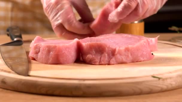 Chef wearing disposable gloves seasoning pork — Stock Video