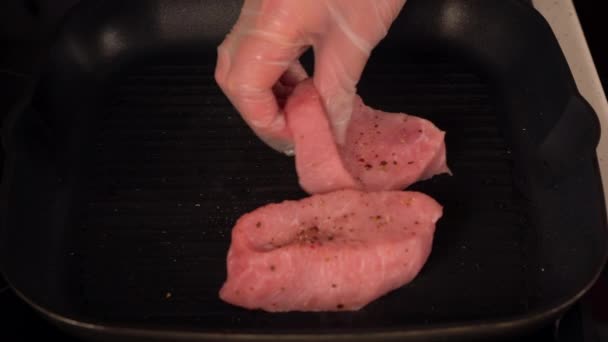 Женщина в одноразовых перчатках готовит свинину — стоковое видео