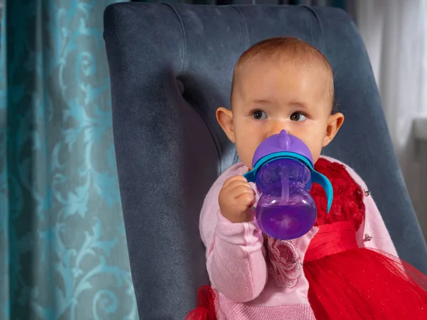 Little baby girl drinking from a plastic bottle — Stock Photo, Image