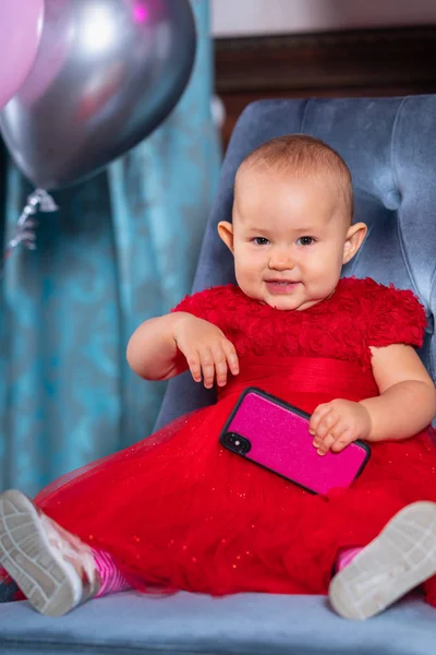 Happy little baby girl in a bright red dress — Stock Photo, Image