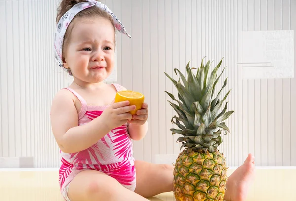 Ung flicka skrynkling ansikte av syrlig frukt — Stockfoto