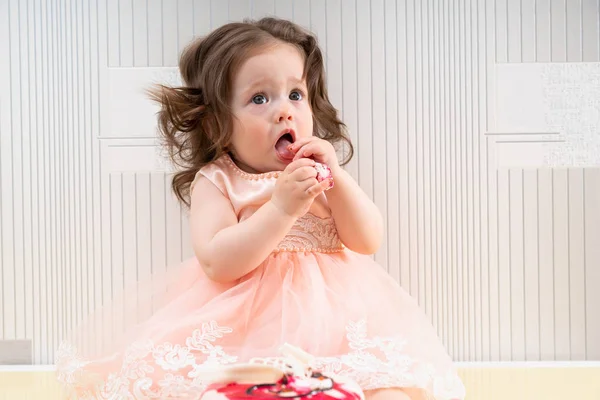 Bébé fille manger gâteau sucré avec ses mains — Photo