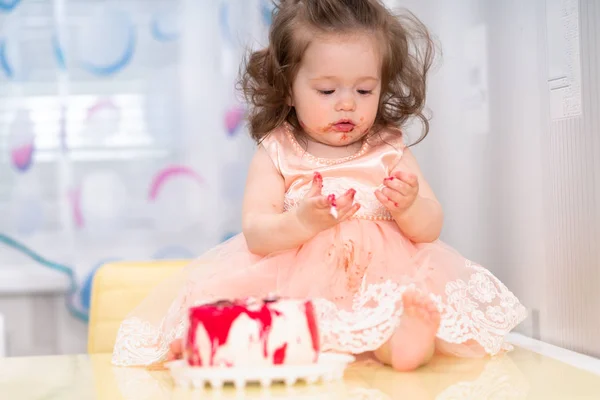 Cute little girl looking at her sticky hands — Stock Photo, Image