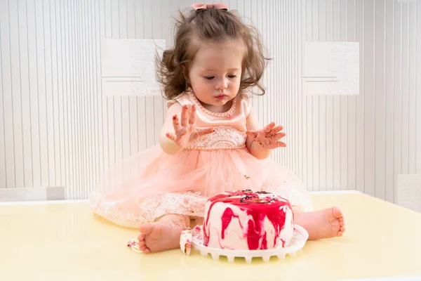 Eager little girl enjoying eating a birthday cake — Stock Photo, Image
