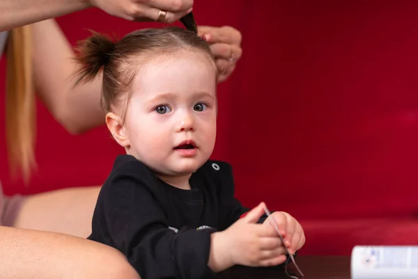 Mamma flätar håret baby döttrar — Stockfoto